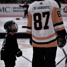 a young hockey player standing next to an adult