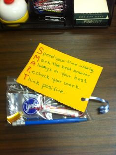 a note sitting on top of a wooden table next to a pen and some pens