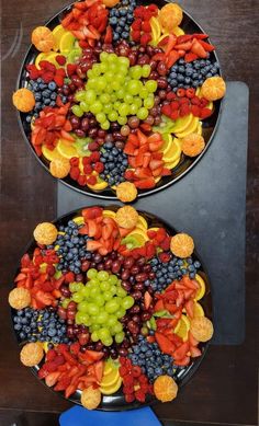 two plates filled with fruit on top of a table