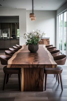 a large wooden table sitting in the middle of a room with lots of chairs around it