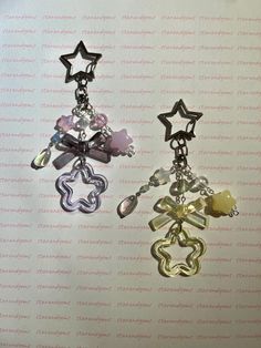 two earrings with charms hanging from them