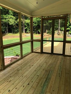 an empty porch with wood flooring and sliding glass doors