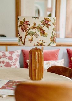 a lamp sitting on top of a wooden table next to a chair in a living room