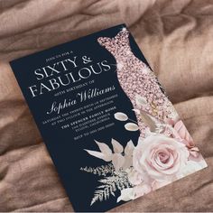 a wedding card with flowers on it sitting on top of a bed next to a pillow