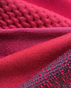 red and purple fabric with stitching on it, closeup shot in full frame