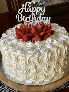 a birthday cake with white frosting and strawberries on top