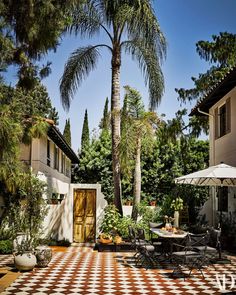 an outdoor dining area with checkered tile flooring and palm trees