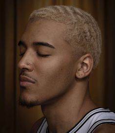 a young man with his eyes closed wearing a basketball jersey and looking to the side