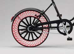 a black and red bike with wheels on it's front wheel spokes are shown