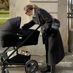 a woman pushing a stroller with a baby in it