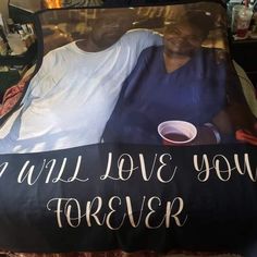 two people are laying on a bed with a sign that says, i will love you forever