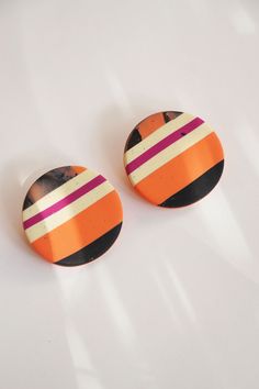 two orange and black striped buttons on a white surface