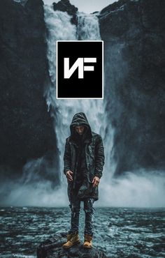 a man standing in front of a waterfall with the word n on it's face