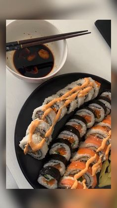 sushi and chopsticks on a black plate