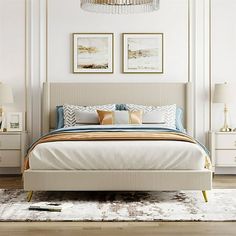 a large bed sitting next to two lamps on top of a wooden floor in a bedroom