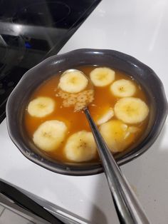 a bowl filled with bananas sitting on top of a stove