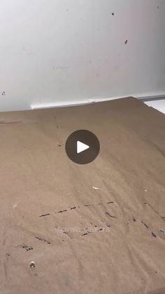 an open cardboard box sitting on top of a white floor with holes in the bottom