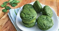 four green cookies are on a white plate