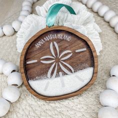 a wooden ornament with an image of a sand dollar on it and some beads around it