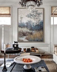 a living room filled with furniture and a chandelier hanging from the ceiling next to a painting