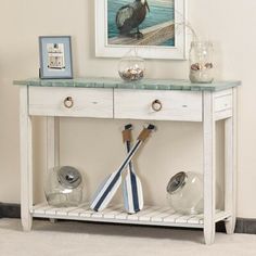 a white table with two umbrellas on it and a bird painting above the table