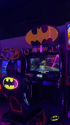 a batman themed video game machine in a dark room with neon lights on the walls