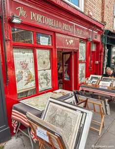 an outdoor shop with many framed pictures on the outside and in front of it's windows