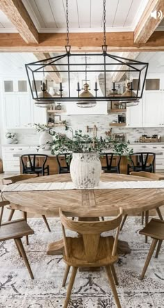 a dining room table with chairs and a potted plant on top of the table