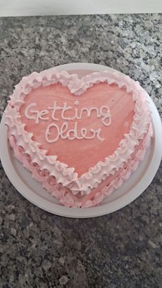 a heart shaped cake with the words getting older written on it