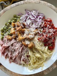 a white plate topped with pasta and meat