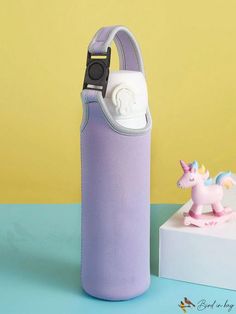 a purple case with a unicorn figurine on it next to a small camera