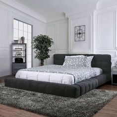 a large bed sitting on top of a hard wood floor next to a book shelf