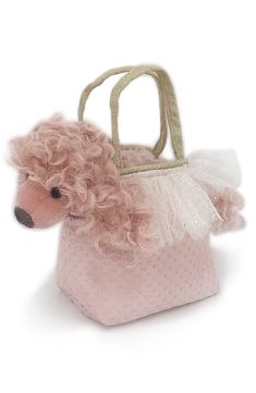 a stuffed poodle in a pink purse on a white background