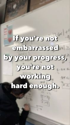 a person writing on a whiteboard with the caption if you're not embarrassed by your progress, you're not working hard enough