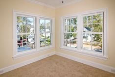 an empty room with three windows and no one in the room or there is a car parked on the street