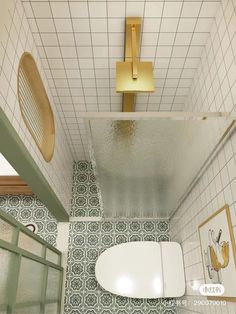 an overhead view of a bathroom with green and white tiles on the floor, walls and ceiling