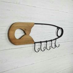 a wooden cutting board mounted to the side of a wall with scissors hanging from it