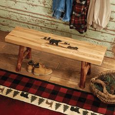 a wooden bench sitting on top of a red rug next to a pile of shoes