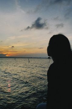 a person sitting on a boat watching the sunset