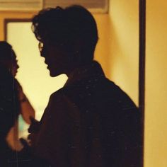 two people standing next to each other in front of a mirror with the reflection of them