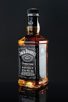 a bottle of jack daniels whiskey on a reflective surface