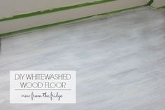 whitewashed wood floor being painted with green tape