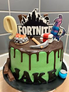 a birthday cake with chocolate icing and fondant decorations for fortnit's