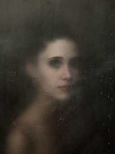 a blurry photo of a woman's face through a window