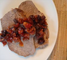 meat with raisins and sauce on a white plate