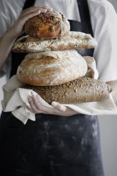 a person holding a bunch of bread in their hands