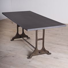 a rectangular table with metal legs on a hard wood floor