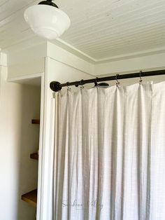 a bathroom with a shower curtain and light fixture