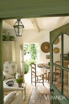 an open door leading to a living room with chairs and table in the background,