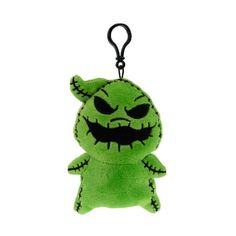 a green stuffed toy with black eyes and fangs on it's face is hanging from a hook